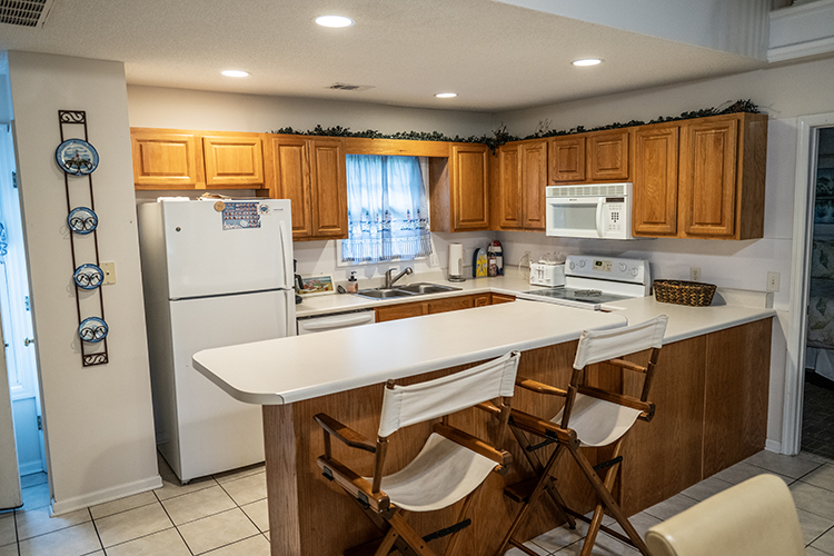 Kitchen area with washer dryer dishwasher and microwave